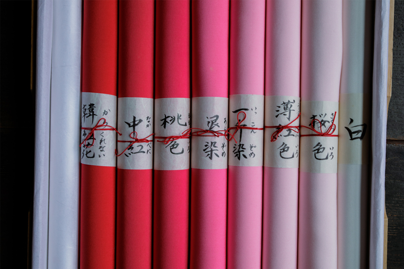 紅花で染められた生地が淡い色から濃い色までグラデーションで並べられている