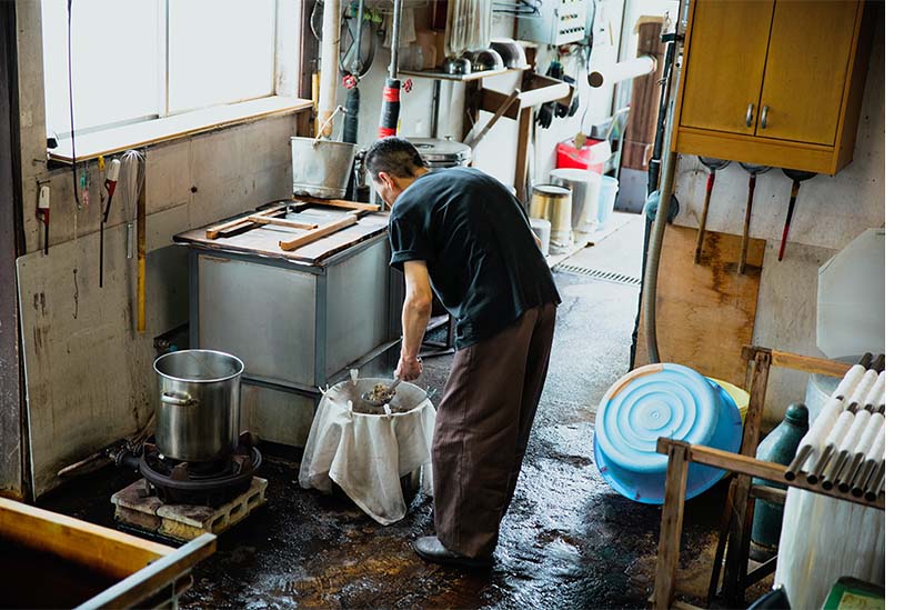 染料を作るために原料を煮詰める職人