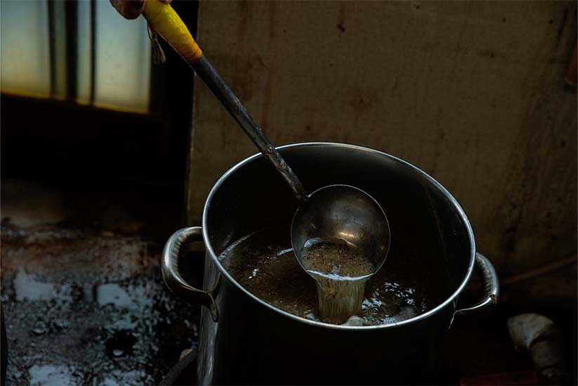 染料を作るために原料を煮詰める職人