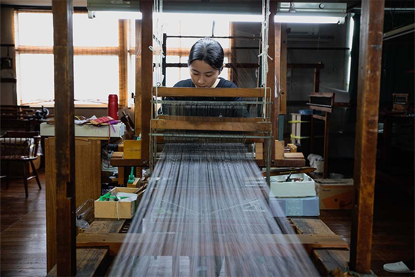 高機で織物を作る職人