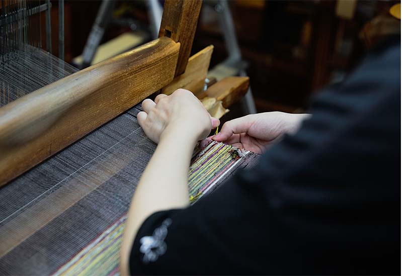 高機で織物を作る職人