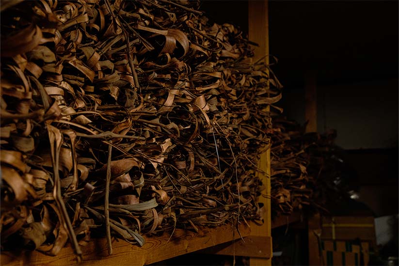 倉庫に寝かされている編カゴの原料であるやまぶどうのツル