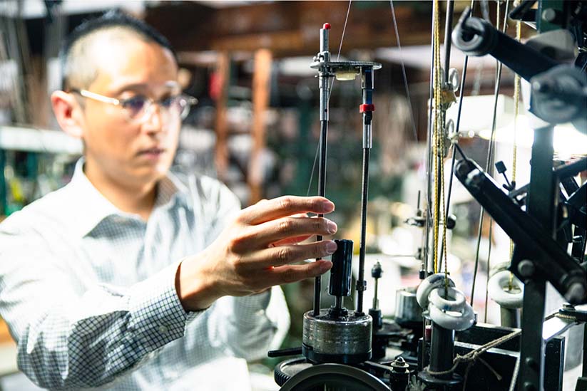 織機に糸をセッティングする俊宏さん