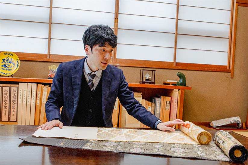 帯を見せながら語る小森織物の小森一彌氏